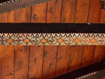 ...dotato di capriate decorate da una successione di cerchi con temi floreali stilizzati che riprendono la fantasia �a dente di lupo� dell�esterno